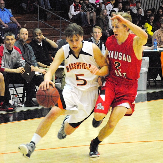 Marshfield's Isaac Accola blows past Wausau East's Travis Waldvogel during the first half of the Tigers' 69-65 win on Friday night at Marshfield High School. (Photo by Paul Lecker/MarshfieldAreaSports.com)