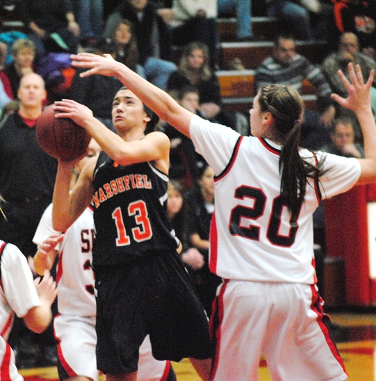 Marshfield sophomore Caitlin Michaelis slides past Stevens Point's Heather Woyak to score during the Tigers' 63-50 loss at SPASH on Tuesday night. (Photo by Paul Lecker/MarshfieldAreaSports.com)