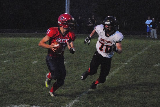 Spencer/Columbus Catholic's Noah Zastrow is forced out of the pocket by Stanley-Boyd's Eric Hoffstatter during the second quarter of Friday's game at Spencer High School. Zastrow turned the play into a 63-yard touchdown run. (Photo by Paul Lecker/MarshfieldAreaSports.com)